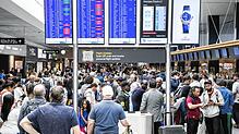 Fluggäste warten vor einer Anzeigetafel auf dem Flughafen in Zürich (Archivfoto). Weil Personal für die Sicherheitskontrollen fehlt, ...