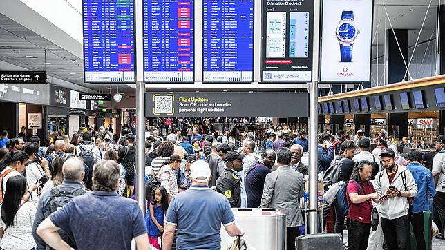 Fluggäste warten vor einer Anzeigetafel auf dem Flughafen in Zürich (Archivfoto). Weil Personal für die Sicherheitskontrollen fehlt, ...