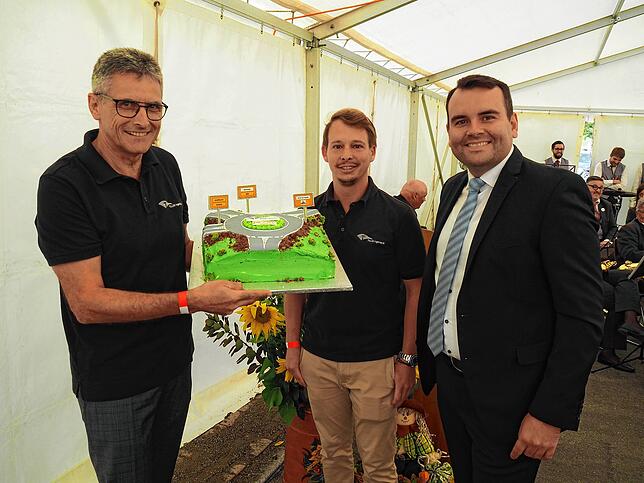 Der neue Kreisverkehr als Kuchen. Darüber freuen sich (von links): Ralf Mülhaupt, Andree Binninger (beide Ingenieurbüro Tillig) und ...