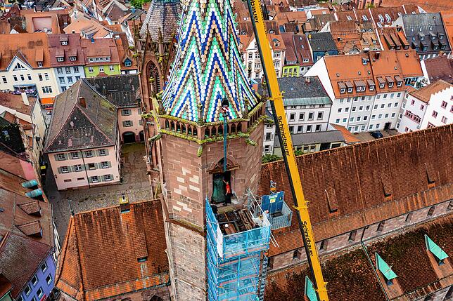 In luftiger Höhe im Südturm verrichten die Handwerker ihre schwierige Arbeit: Sie müssen die tonnenschwere Glocke ausbauen.