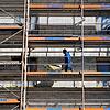 Ein Arbeiter geht auf der Baustelle eines Wohnhauses in Berlin mit einer Schubkarre über das Baugerüst. In Deutschland fehlen ...