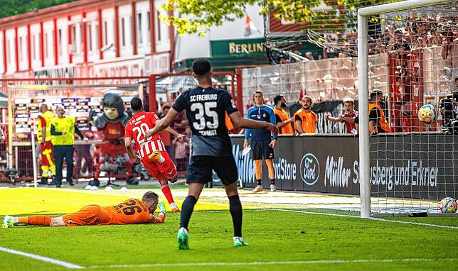 Berlins Aissa Laidouni (M) überwindet Torwart Mark Flekken (l) von SC Freiburg zum 4:2.