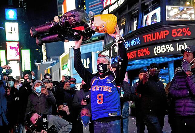 In New York hält ein Demonstrant eine Trump-Puppe am Times Square hoch