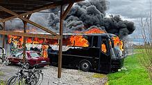 Flammen schlagen aus den Scheiben des Busses.