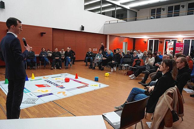 Die Zuhörer beim Wahlopoly hören Jan-Lukas Schmitt (Die Grünen) zu, der gerade eine Frage beantwortet.