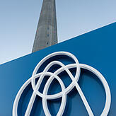 Das Logo von Thyssenkrupp steht vor dem 246 Meter hohen Testturm. Foto: Patrick Seeger/dpa