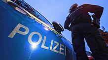 Eine Polizistin steht neben einem Polizeifahrzeug. (Symbolfoto)