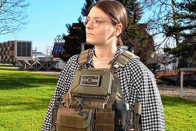 Antonija Kiourtsidis probiert eine Weste der Bundeswehr an und erkundigt sich darüber.
