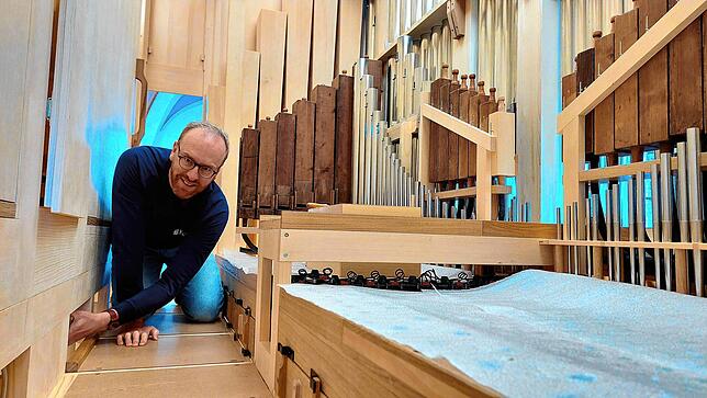 Orgelbauer Johannes Uhlmann ist in das Innere der Orgel geklettert, die an ein edles Möbelstück erinnert. Hinter den Klappen befindet ...