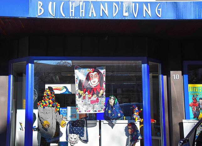 Ein Kuony-Banner und Masken im Schaufenster bei Buch Hierling an der Kirchhalde.