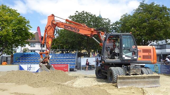 Ein Bagger verteilt Sand auf dem Landungsplatz.