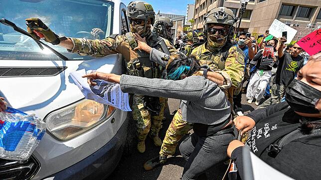09.06.2025, USA, Santa Ana: Die Polizei setzt Pfefferspray ein, um Demonstranten von einem Lieferwagen zu entfernen, der das ...