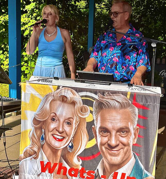 Im Halbschatten neben dem Aachbadbistro schmettert das Duo von Whats-Up bekannte Hits aus den vergangenen Jahrzehnten.