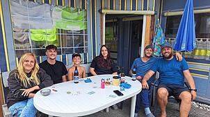 Von links: Tanja Fallenstein, Jonas Schultheiss, Lio und Mia Fallenstein, Anton Sadovoj und Dirk Fallenstein sitzen zusammen und spielen ...
