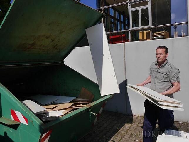 Die meisten Möbel ziehen um, aber diese alten Regale taugen nichts mehr. Manuel Gehner wirft sie in den Müllcontainer.
