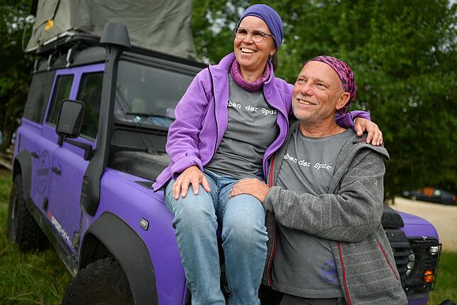 Survival- und Outdoor-Messe Sabine (l) und Burkhard Koch vom Label "Pistenkuh" geben bei der Survival- und Outdoor-Messe neben ihrem Landrover Defender ein Interview.