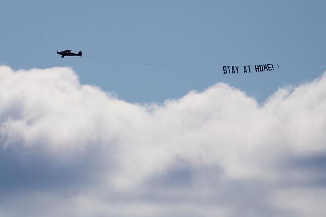 Coronavirus - Hamburg Ein kleines Flugzeug fliegt mit einem Banner mit der Aufschrift «Stay at Home!» (Bleibt zu Hause!) am Himmel über der Innenstadt. Trotz ...