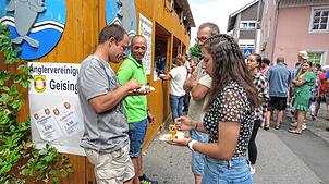 Fingerfood gehört zum Straßenfest in Geisingen dazu. Auch diese vier Besucher lassen sich die Spezialitäten der Angler munden. Fotos: ...