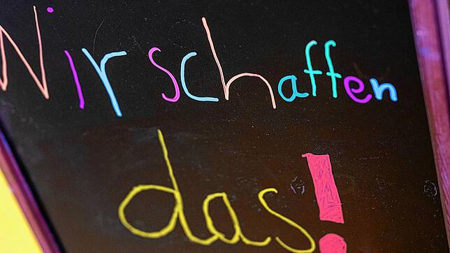 Der Schriftzug &ldquo;Wir schaffen das!&bdquo; ist auf einem Aufsteller in einer Schule zu lesen. Ab Montag sollen die Einrichtungen ...