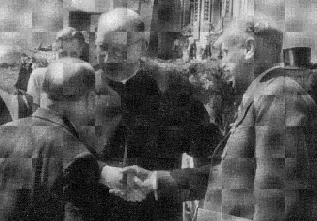 Prälat Arthur Allgeier beim Händeschütteln nach seiner Festrede anlässlich der Stadterhebung 1950: Rechts Innenminister Schühly, vor ...