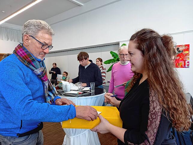 Peter Müller-Neff (FGL) gibt seinen Wahlzettel an der Urne bei Rosa Buss ab.