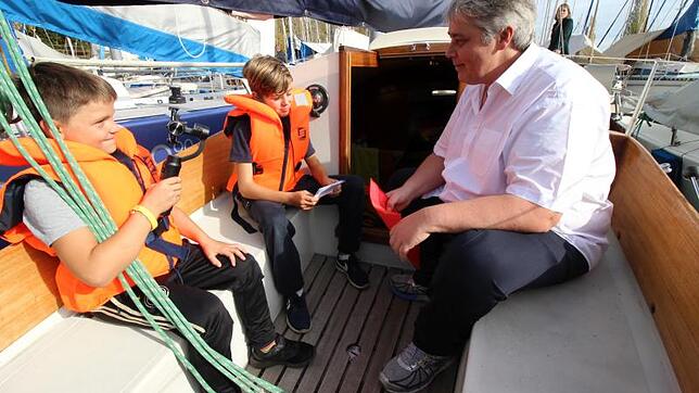Interview im Segelboot: Michael Reutlinger (rechts) wird von Kindern des Linzgau Kinder- und Jugendheims Deisendorf gefilmt und befragt. ...