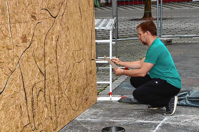 Anhand der Vorlage prüft Nikolaj Arndt, ob seine Vorzeichnung des Dinosauriers T Rex stimmt. Bild: Bernhard Lutz