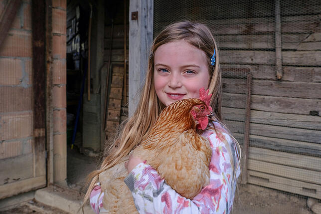 Tierlieb: Emily Wolf, 7, kuschelt mit einem der Hühner.