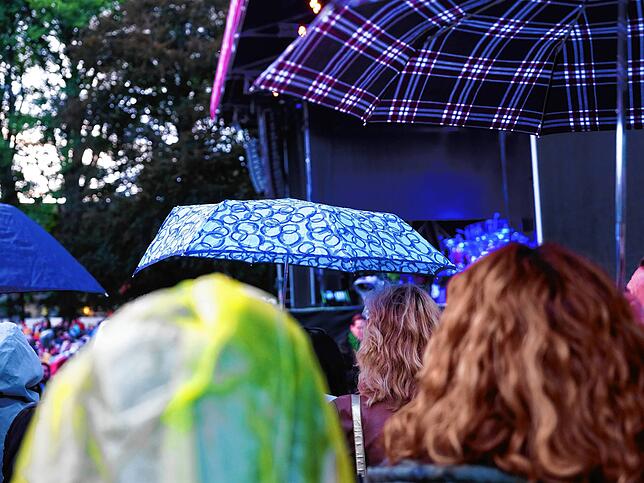Regenschirme versperren die Sicht auf die Bühne.