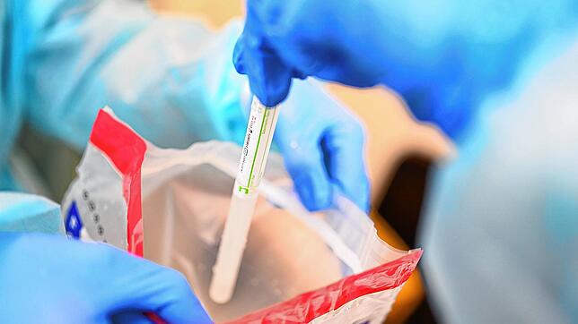 Corona-Test: Eine Ärztin gibt einen Abstrichstäbchen im Plastikröhrchen in einen Plastikbeutel, nachdem sie einem Patienten in einem ...
