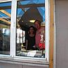 Jelena und Damir Dokic schauen durch die zerstörte Fensterscheibe ihres Imbiss, in den sie viel Geld und Arbeit investiert haben.