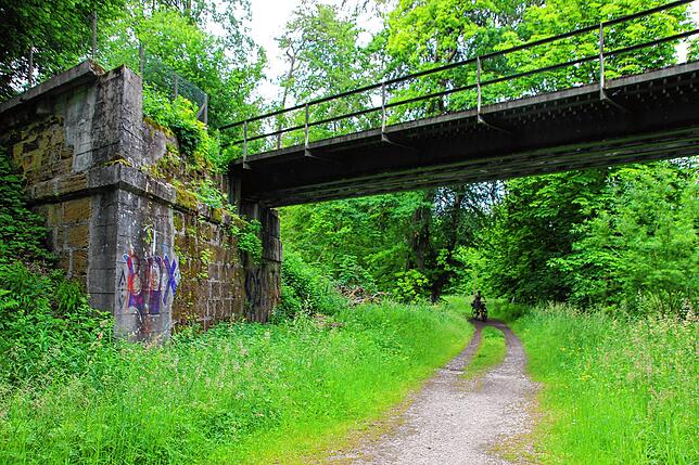 Unter der einstigen Bahnbrücke im Park hindurch geht es zum Naturschutzlehrpfad Ablacher Seen.