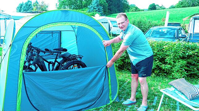 Ihre neuen E-Bikes haben Silke und Dietmar Hesselbach im Trockenen geparkt. Das Wurfzelt dient als Fahrradgarage.