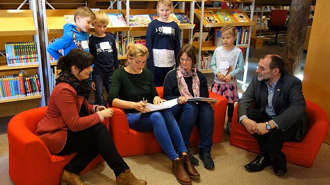 Die Schüler passen auf, dass bei der Unterzeichnung des Kooperationsvertrags zwischen der Stadtbücherei und der Wiestorschule alles ...