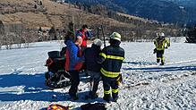 Angehörige der Bergwacht und der Feuerwehr Todtmoos helfen der verletzen Wanderin auf einen Motorschlitten, mit dem sie abtransportiert ...