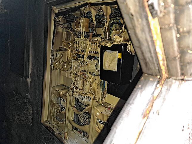Blick auf den Elektrokasten mit deutlichen Brandspuren.
