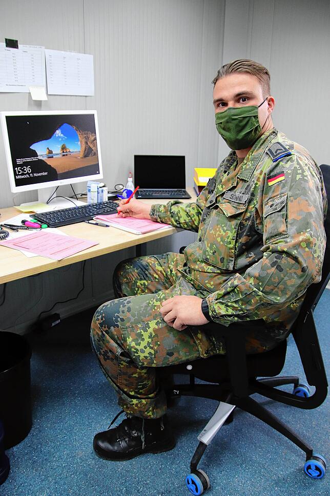 Heinrich Schwind sitzt an seinem Schreibtisch im engen Container. Mit einer Liste arbeitet er die Kontakte telefonisch nacheinander ab.