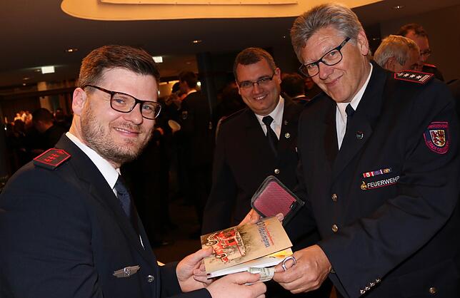 Frisch gedruckt: Simon Hall (links) verkauft die Festschrift an Karl Czech. Rainer Waldvogel freut sich ebenso über das gelungene Werk.