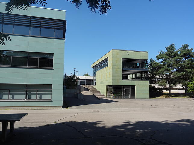 Blick auf das Friedrich-Wöhler-Gymnasium im Jahr 2019 vom Aachuferweg aus. Der würfelähnliche Anbau beherbergt die Mensa.