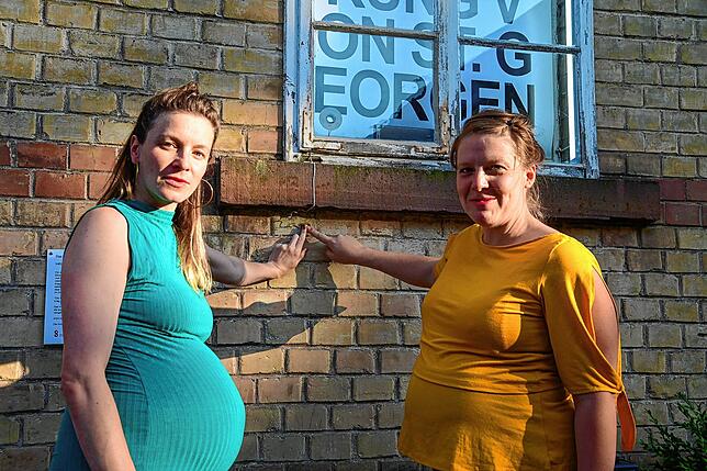 Katharinajej (links) und Julia Dick drücken den Knopf, der die Hör-Installation am Hörfenster in der Friedrichstraße 5a abspielt.