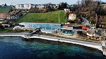 Aus der Luft ist links der halbrunde Gastronomieanbau zu sehen sowie der gläserne Anbau für die Sauna zwischen Hauptgebäude und den ...