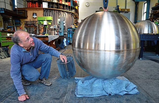 Der Deggenhausertaler Metallkünstler David Fuchs in seinem Atelier neben einer der beiden Bronzekugeln für den neuen Rathausbrunnen. Aus ...
