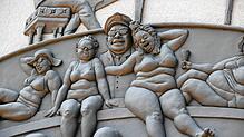 Ein Teil des Narrenschiffs von Peter Lenk an der Außenwand des Seeums in Bodman. Eine Führung erläutert das Kunstwerk.