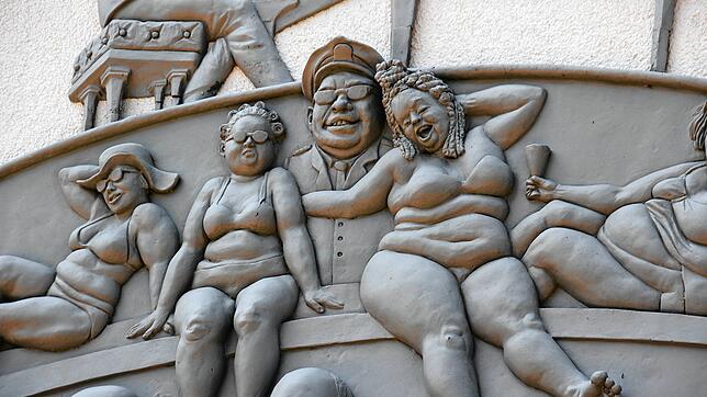 Ein Teil des Narrenschiffs von Peter Lenk an der Außenwand des Seeums in Bodman. Eine Führung erläutert das Kunstwerk.