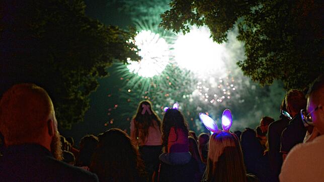 Ein großer und ein kleiner „Seehas“ schauen dem Feuerwerk aus der Menschenmenge an der Uferpromenade heraus zu. Bild: Lena Reiner