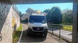 Ein Mann zwängt seinen Lieferwagen in Birmenstorf bei Baden in der Schweiz auf dem Radweg unter eine viel zu niedrige Brücke. Der ...
