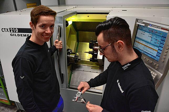 Julian Jurtz und Matthias Hiestand (von links) stehen vor der CNC-Drehmaschine, mit der Ringe und der ...