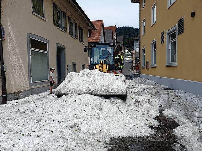Der kleine Magnus schaut fasziniert auf den Schaufelradlader der Gemeinde, mit dem nach dem Hagelschauer im Dorf der Weg frei gemacht wird.