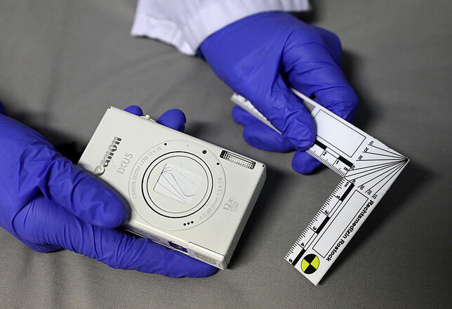 Mit einem Fotoapparat und einem Winkellineal werden Verletzungen dokumentiert.