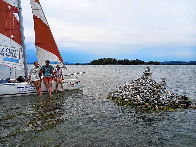 Carla, Michael und Tini Wendtland (von links) aus Allensbach haben mit ihrem Boot an der Steinskulptur vor der Liebesinsel Halt gemacht. ...